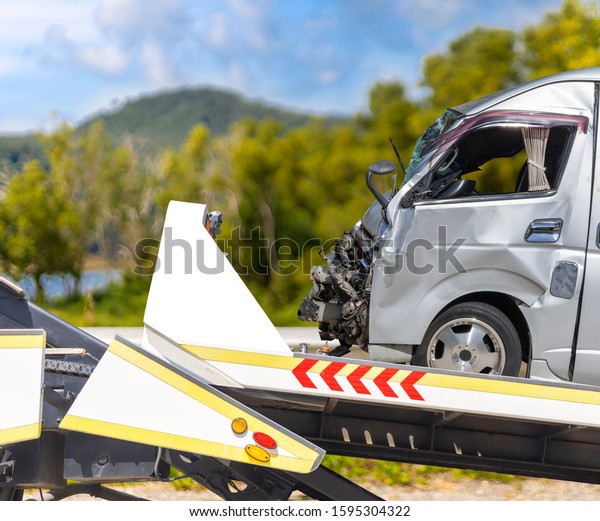 accident Car Slide on\
truck for move. van car have damage by accident on road take with\
slide truck move .