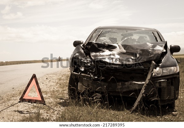accident car and\
warning triangle beside\
road