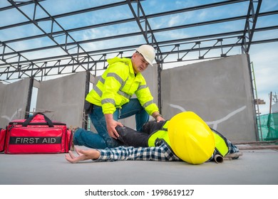 Accident At Construction Site. Physical Injury At Work Of Construction Worker. First Aid Help A Construction Worker Who Accident At Construction Site. First Aid Help At Accident In Constructions Work.