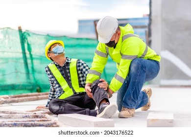 Accident At Construction Site. Physical Injury At Work Of Construction Worker. First Aid Help A Construction Worker Who Accident At Construction Site. First Aid Help At Accident In Constructions Work.