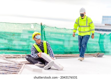 Accident At Construction Site. Physical Injury At Work Of Construction Worker. First Aid Help A Construction Worker Who Accident At Construction Site. First Aid Help At Accident In Constructions Work.