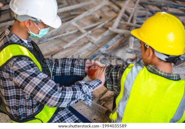 Accident at construction site. Physical injury\
accident at work of construction worker. Emergency medical teams\
are first aiding a construction worker who has an accident at a\
construction site.