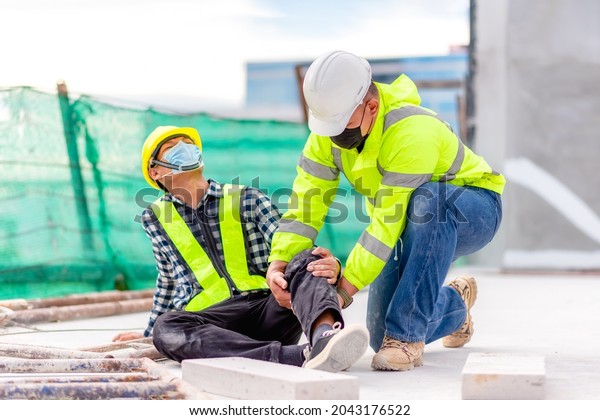 Accident at construction site. Physical injury at
work of construction worker. First Aid Help a construction worker
who accident at construction site. First Aid Help at accident in
constructions work.
