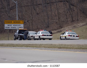 Accident With Fender Bender Road Sign.  Police Car And Tow Truck Wrecker At Scene