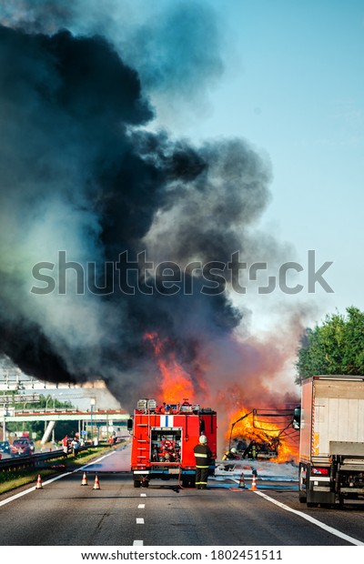 accident and fire on the road vertically, truck\
in fire with black smoke on the\
road