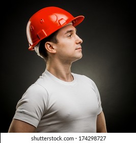 Accident Prevention - Safety Helmet. White Man In A Protective Helmet Construction In The Studio On A Black Background In Profile