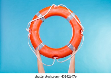 Accident prevention and water rescue. Life buoy ring lifebelt in female hands studio shot blue background