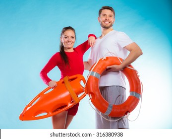 Accident Prevention And Water Rescue. Young Man And Woman Lifeguard Couple On Duty Holding Buoy Lifesaver Equipment On Blue