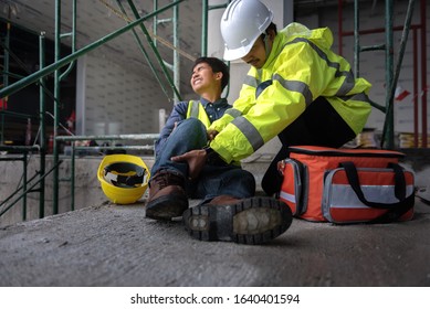 Accident At Work Of Construction Worker At Site. Builder Accident Falls Scaffolding On Floor, Safety Team Helps Employee Accident.