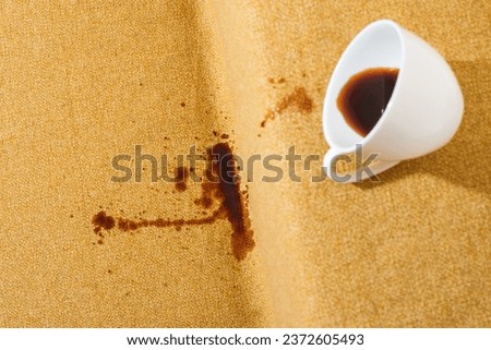Accidental coffee spill on the sofa, creating a brown stain that marred the upholstery, sofa or couch. Spoiled fabric-covered. Cleaning and stain removal concept. High quality photo