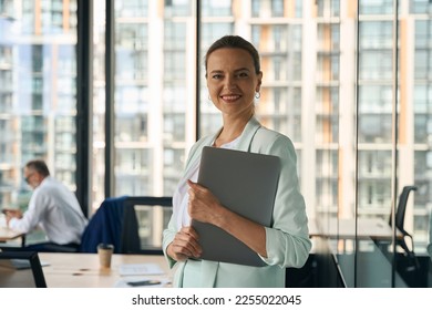 Accomplished female entrepreneur smiling proudly at her workplace - Shutterstock ID 2255022045