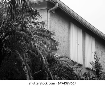 Accordion Hurricane Shutters Are Covering Second Story Windows In Preparation For An Impending Storm In Black And White.