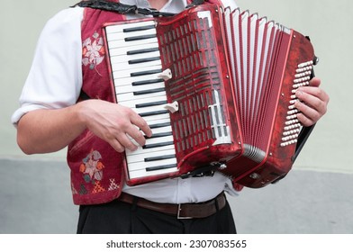 an accordion player plays in the street during a party.Detail of the hands