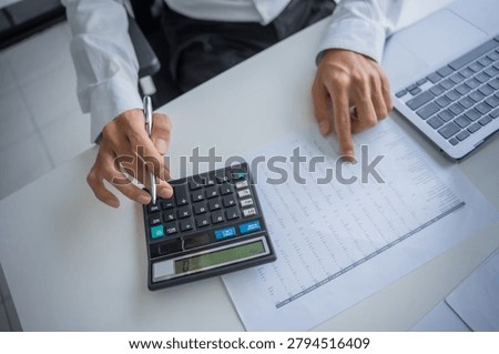Accountant using calculator calculate document.