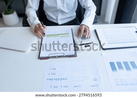 Accountant using calculator calculate document