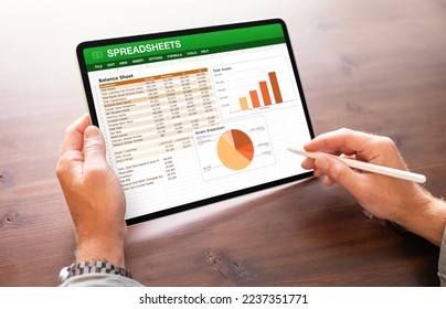 Accountant viewing financial data spreadsheets on the screen of tablet computer