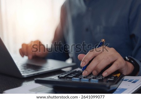 Accountant working hands using calculator and laptop. business finance planning at desk with financial tax documents invoice , pen, and technology management payroll online internet banking concept.