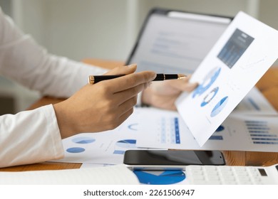 Accountant working on consolidated financial report of corporate operations, consultant auditing finance data (balance sheet, income statement) on laptop with business charts, fintech. - Shutterstock ID 2261506947