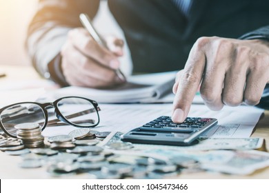 accountant working on desk in office using calculator to calculate budget. concept finance and accounting