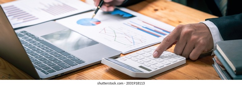accountant working on a desk using calculator for calculating finance report in office, Annual tax calculation finances, and economy concept. Financial calculation concept, Accounting , Economic - Shutterstock ID 2031918113