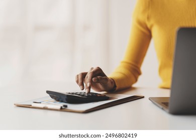 Accountant working on desk using calculator to calculate financial report in office business accounting finance concept - Powered by Shutterstock