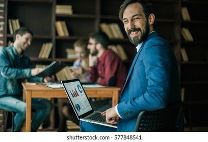 Accountant Works With Financial Charts On The Laptop In The Offi