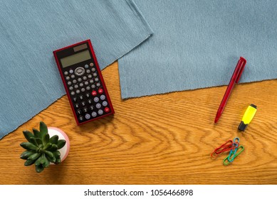 Accountant Workspace As Flat Lay From Above With Blank Calculator Display, Plant, Marker Pen And Paper Clips With Wooden Background