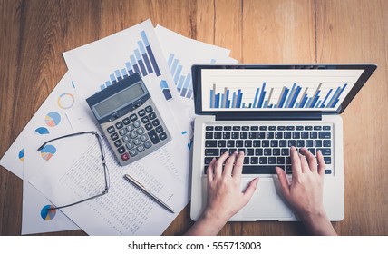 Accountants work analyzing financial reports on a laptop. - Shutterstock ID 555713008