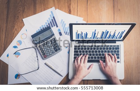 Accountants work analyzing financial reports on a laptop.