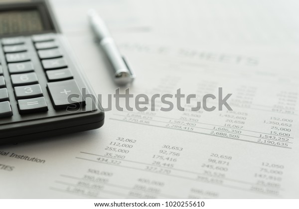 Accounting business concept.\
Calculator with accounting report and financial statement on\
desk.