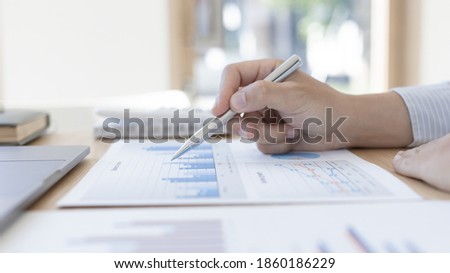 Accounting businessmen are calculating income-expenditure and analyzing real estate investment data, He works on a desk has graphs and calculators with laptop, Financial and tax systems concept.