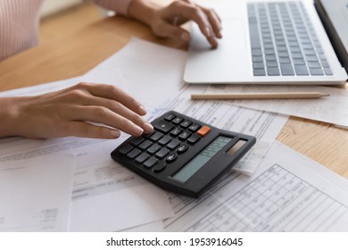 Accounting is an exact science. Close up cropped view of young woman enterpreneur hands doing financial paperwork check money savings sum on bank account calculating goods service price paying bills