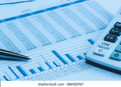 Accounting financial banking stock spreadsheet data with pen and calculator in blue  - Shutterstock ID 386502967