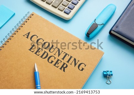Accounting ledger, notepad and calculator on the desk.