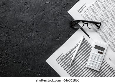 accounting work space with calculator, profit and tables on dark desk top view mock-up - Shutterstock ID 646361860
