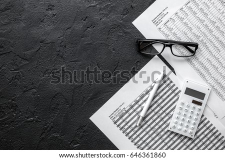 accounting work space with calculator, profit and tables on dark desk top view mock-up