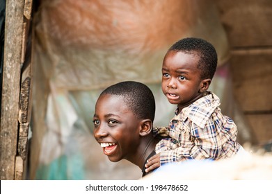 ACCRA, GHANA - MARCH 4, 2012: Unidentified Ghanaian boy carries his brother on his back in the street in Ghana. Children of Ghana suffer of poverty due to the unstable economic situation