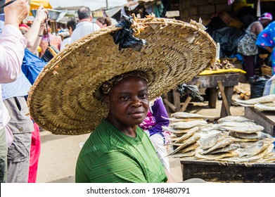 ACCRA, GHANA - MARCH 4, 2012: Unidentified Ghanaian woman portrait in a huge hat in Ghana. People of Ghana suffer of poverty due to the unstable economic situation