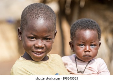 ACCRA, GHANA - MARCH 6, 2012: Unidentified Ghanaian boy holds his little brother on his hands in the street in Ghana. Children of Ghana suffer of poverty due to the unstable economic situation