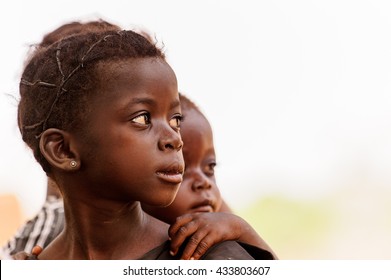 ACCRA, GHANA - MARCH 6, 2012: Unidentified Ghanaian girl and her little brother in the street in Ghana. Children of Ghana suffer of poverty due to the unstable economic situation