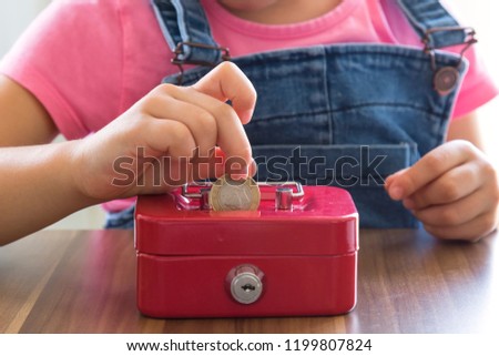accumulate for poor people or investment .coins,hand and red moneybox on the white background for charity foundation concept.child throwing money into piggy bank.