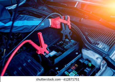 Accumulator charging. Hands and terminals. Car repair. Service station. - Shutterstock ID 612871751