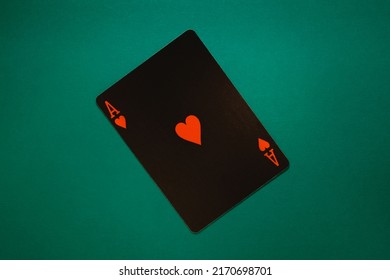 Ace of hearts on a turquoise background. Black poker card ace of hearts close up shot. 