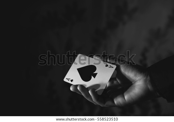 Ace Spade Card in\
Hand, Low-key lighting