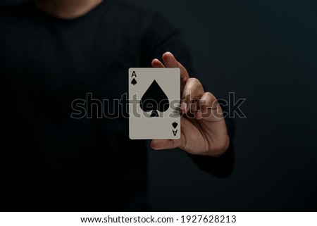 Ace Spade Playing Card. Person Holding a Poker Card. Front View. Closeup and Dark Tone