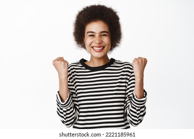 Achievement. Ethusiastic Black Girl Winning Prize, Celebrating Victory, Success, Making Fist Pump And Smiling Satisfied, Standing Over White Background