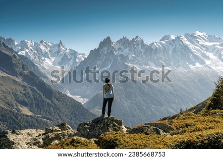 Achievement of female hiker standing with enjoying the Mont Blanc mountain range view during trail in Lac Blanc, French Alps, France