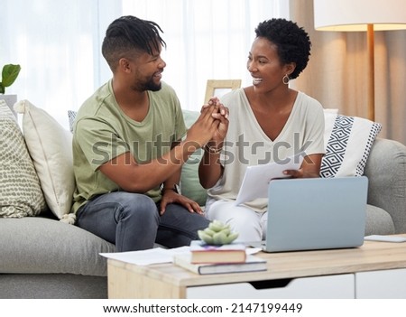 Achieving our goals one step at a time. Shot of a young couple doing paperwork while sitting on the couch at home.