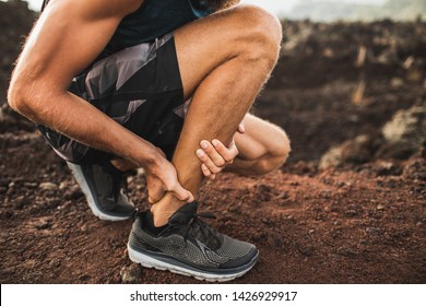 Achillesverletzung beim Laufen im Freien. Mann, der Achilles-Sehnen mit Händen hält, Nahaufnahme und Schmerzen. Sprain-Ligament oder Achilles-Sehnenentzündung.
