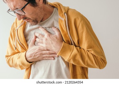 Aching Chest, Adult Male With Painful Grimace Pressing The Upper Abdomen With His Hands To Ease Pain, Pericarditis Concept